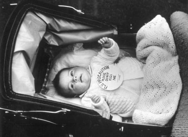 1939 год. Надпись гласит: «Меры предосторожности против гриппа. Пожалуйста, не целуйте меня».